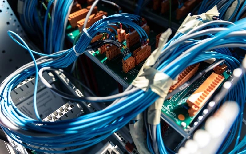 A close up image of electrical wiring, power cables and power supplies.